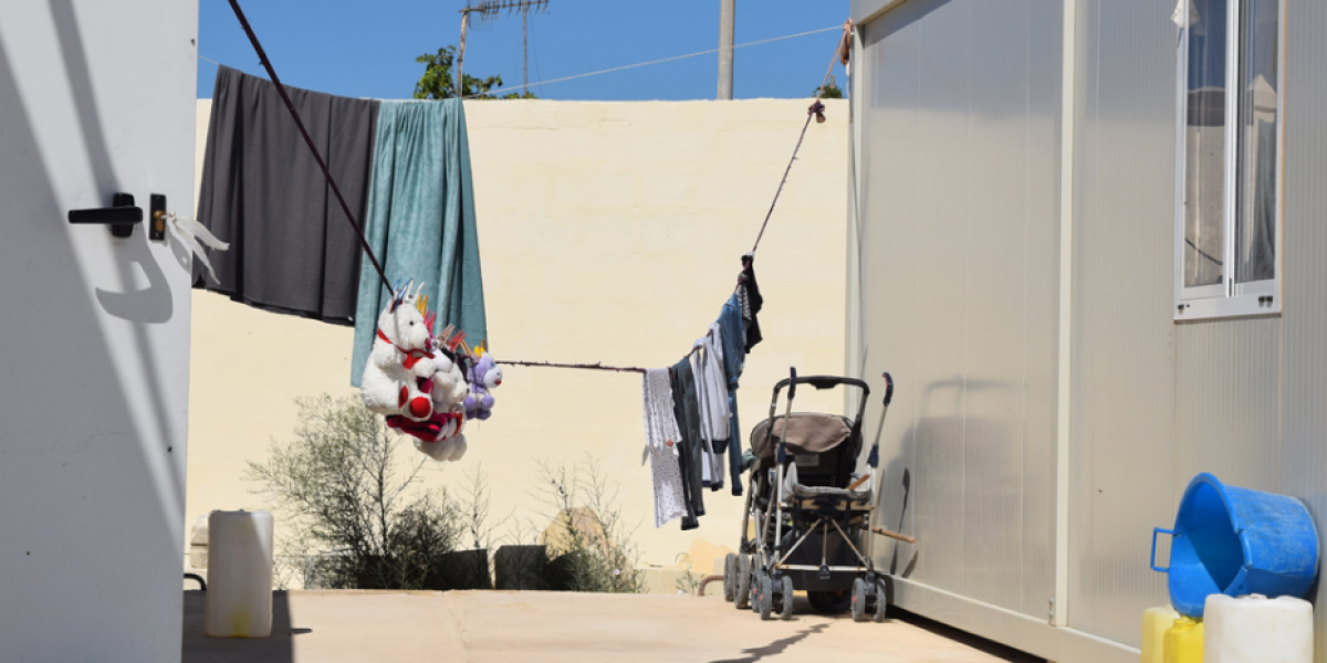 Des peluches d'enfants sont suspendus entre des maisons-containers dans un Centre ouvert à Malte (JRS)