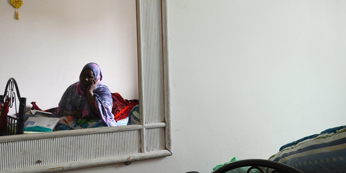 Une jeune Somalienne au téléphone dans son petit appartement, ne comprenant qu’une chambre à coucher, à Amman (JRS)