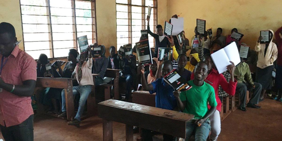 Des étudiants montrent le nouveau matériel scolaire qu’ils viennent de recevoir à Kigoma, Tanzanie (JRS)